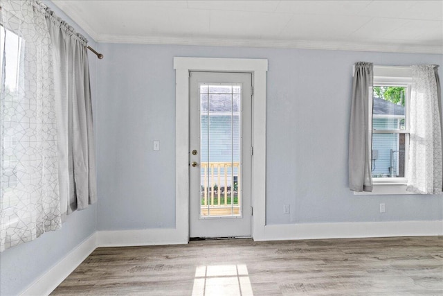 entryway with crown molding, baseboards, and wood finished floors