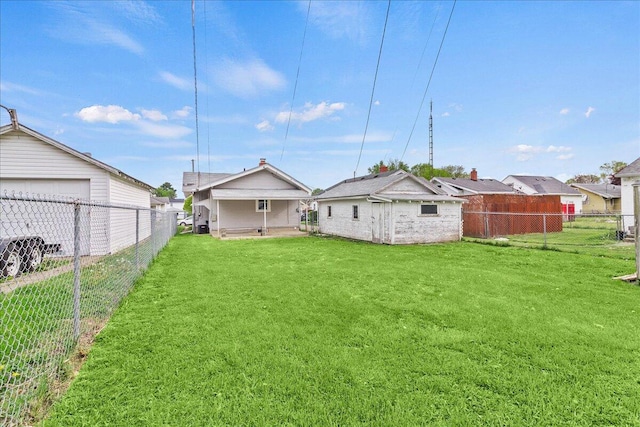 back of property with a lawn, a fenced backyard, and a garage