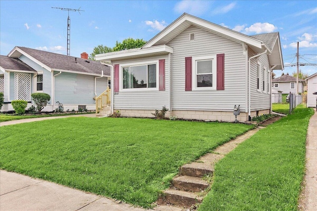 view of front facade with fence, entry steps, and a front yard