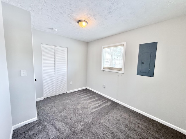 unfurnished bedroom with electric panel, carpet floors, a closet, and a textured ceiling