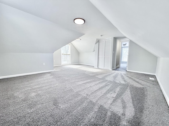 additional living space featuring lofted ceiling and carpet floors