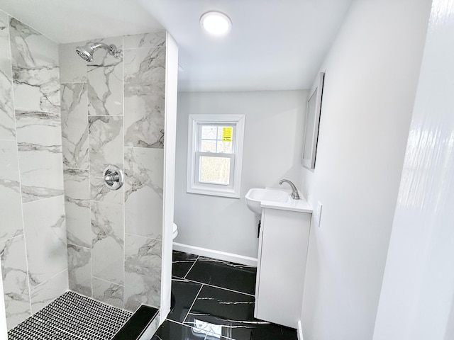 bathroom with vanity, toilet, and a tile shower