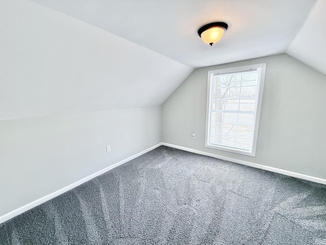 additional living space featuring carpet flooring and vaulted ceiling