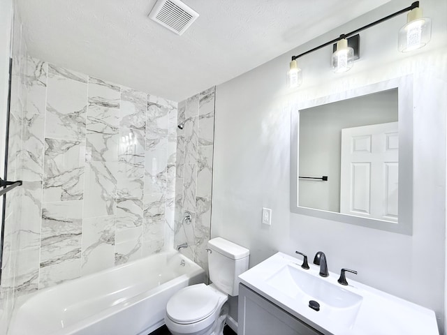 full bathroom with vanity, toilet, tiled shower / bath combo, and a textured ceiling