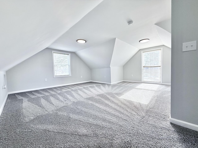 bonus room with vaulted ceiling, carpet flooring, and a wealth of natural light