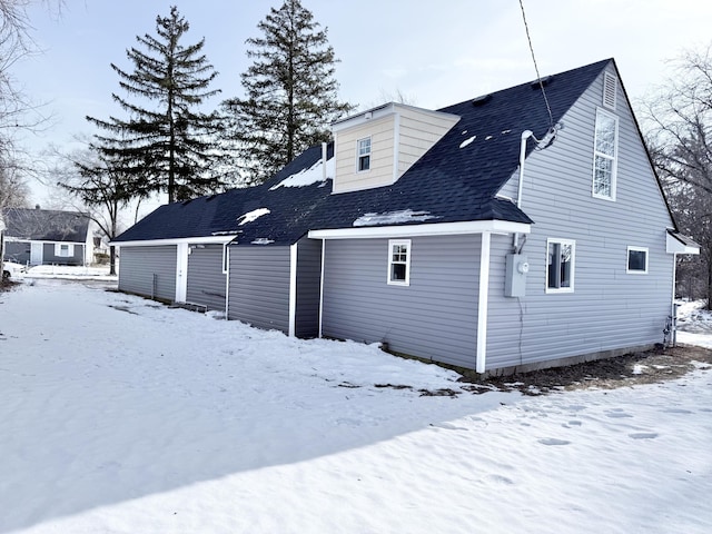 view of snow covered rear of property