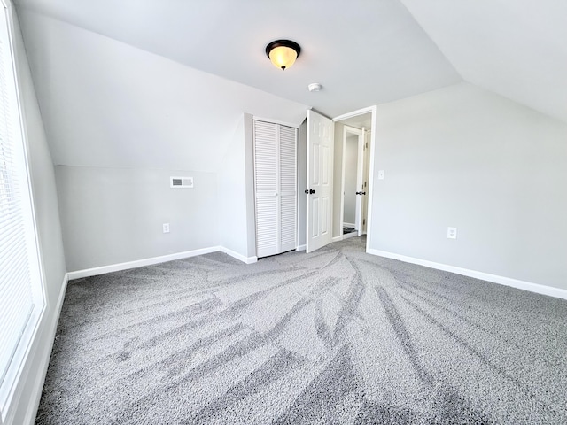 additional living space with lofted ceiling and carpet flooring