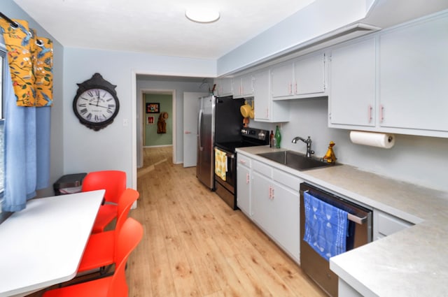 kitchen with dishwasher, electric range oven, sink, and light wood-type flooring