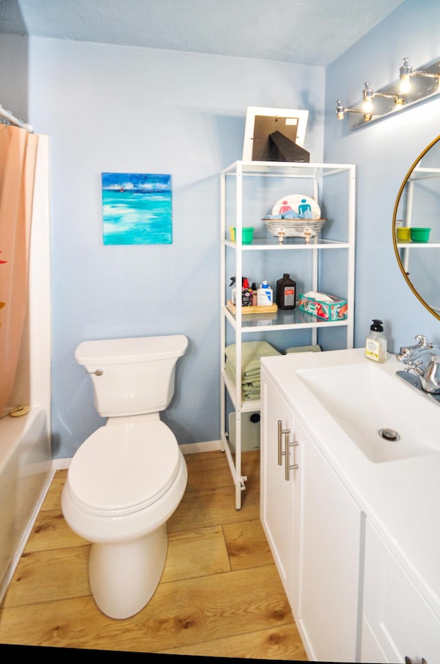 full bathroom featuring shower / tub combo, vanity, hardwood / wood-style flooring, and toilet