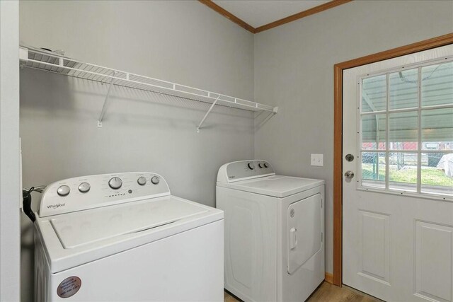 laundry area featuring ornamental molding and washing machine and dryer