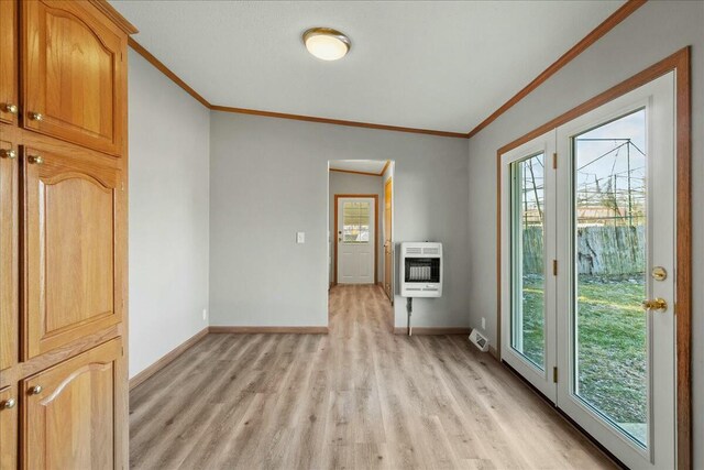 empty room featuring ornamental molding, light hardwood / wood-style floors, and heating unit