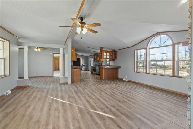 unfurnished living room featuring ceiling fan, sink, light hardwood / wood-style flooring, and lofted ceiling