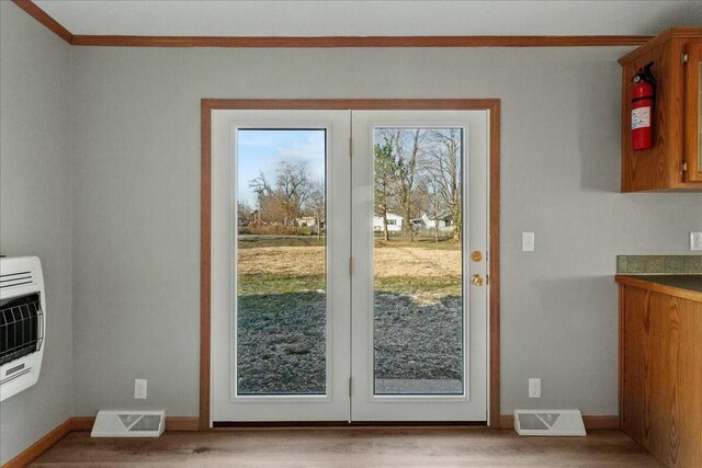 doorway featuring heating unit, light hardwood / wood-style flooring, and french doors