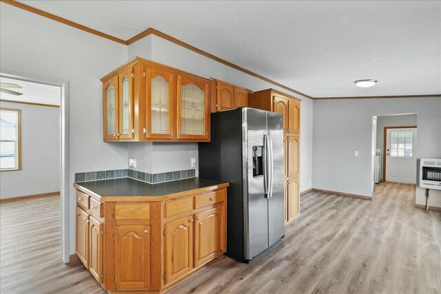 kitchen featuring heating unit, light hardwood / wood-style flooring, crown molding, and stainless steel refrigerator with ice dispenser