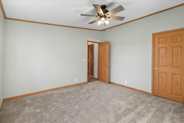 carpeted empty room featuring ornamental molding and ceiling fan