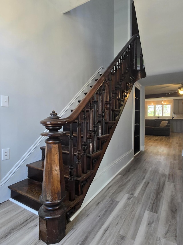 318 W Buckeye St, Belle Center, OH 43310 - staircase with wood finished floors, a ceiling fan, and baseboards