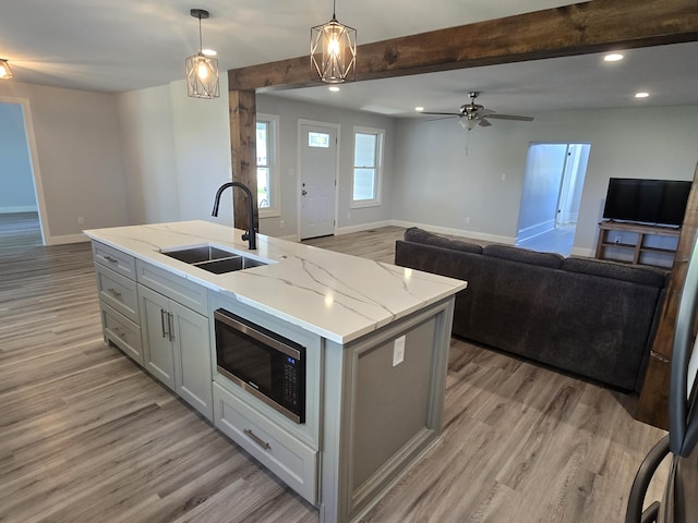 318 W Buckeye St, Belle Center, OH 43310 - kitchen with a sink, stainless steel microwave, gray cabinets, light wood-style flooring, and open floor plan