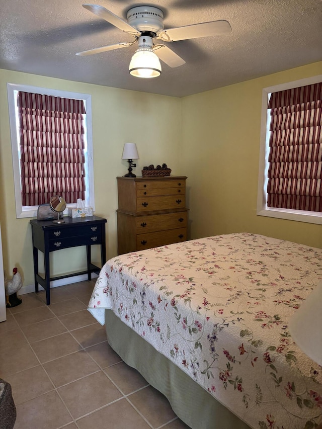 tiled bedroom featuring a textured ceiling and ceiling fan