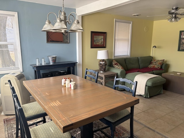dining space featuring heating unit and ceiling fan with notable chandelier