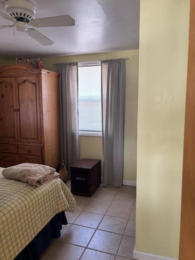 bedroom with light tile patterned floors, a ceiling fan, and baseboards
