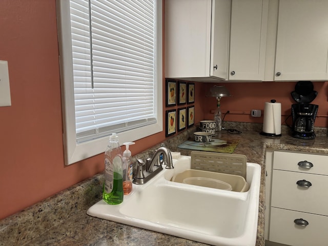kitchen featuring white cabinets and a sink