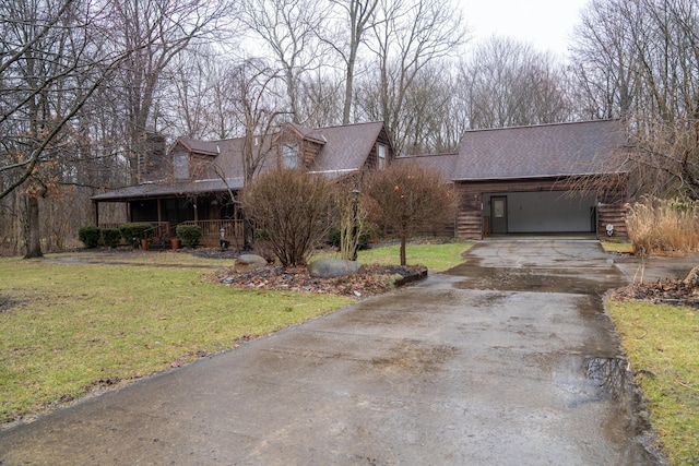 view of front of home with a porch, aphalt driveway, and a front yard