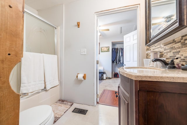 full bath with a shower with door, toilet, vanity, and backsplash