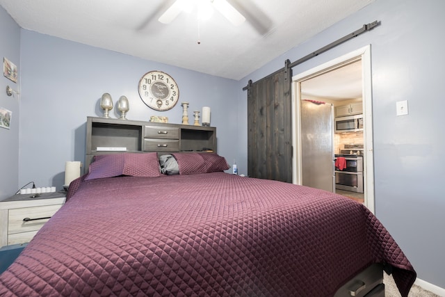 bedroom with a barn door, carpet floors, and ceiling fan