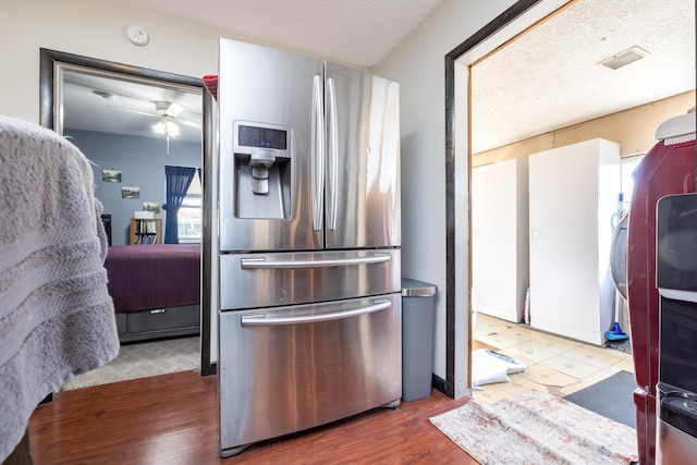 kitchen featuring ceiling fan, a textured ceiling, wood finished floors, and stainless steel refrigerator with ice dispenser