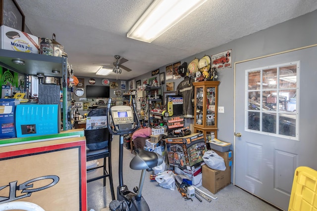 miscellaneous room featuring speckled floor, a textured ceiling, and a ceiling fan