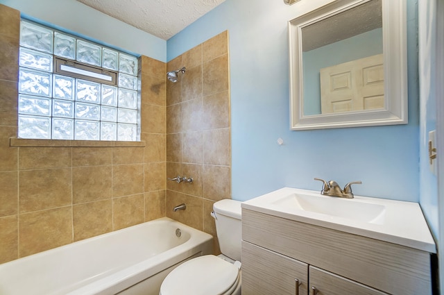 full bathroom with vanity, a textured ceiling, toilet, and tiled shower / bath