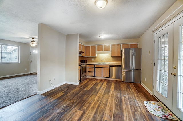 kitchen with tasteful backsplash, sink, stainless steel appliances, dark wood-type flooring, and a textured ceiling