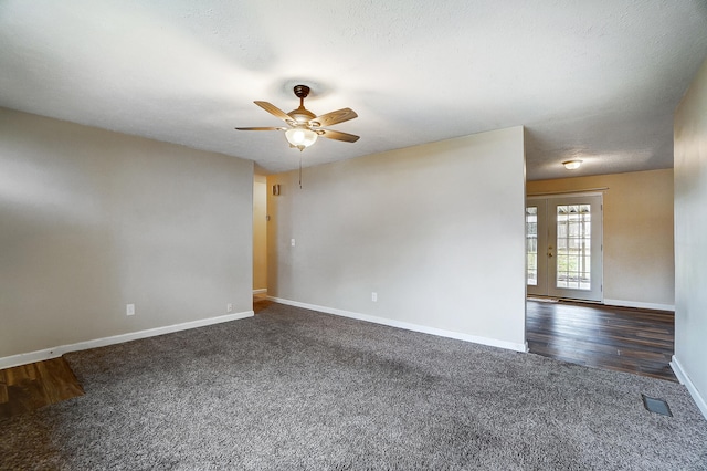 spare room featuring dark carpet, a textured ceiling, french doors, and ceiling fan