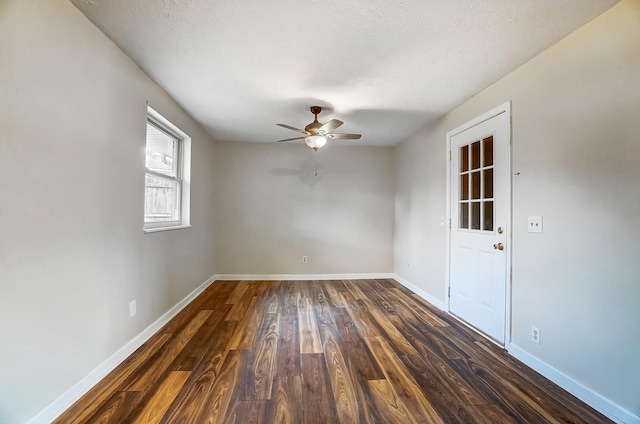 empty room with ceiling fan, a textured ceiling, and dark hardwood / wood-style flooring