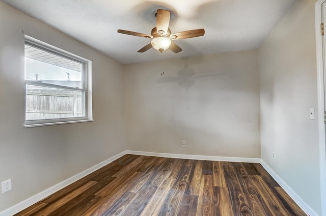 spare room with dark wood-type flooring and ceiling fan