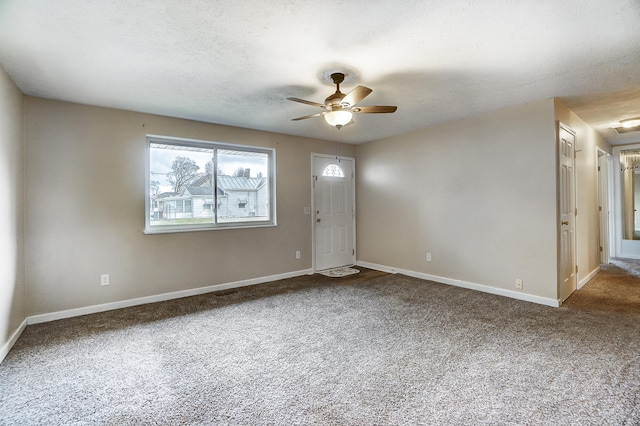 interior space featuring ceiling fan, carpet floors, and a textured ceiling