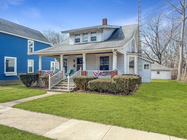 view of front facade featuring a front yard, a porch, roof with shingles, and a chimney