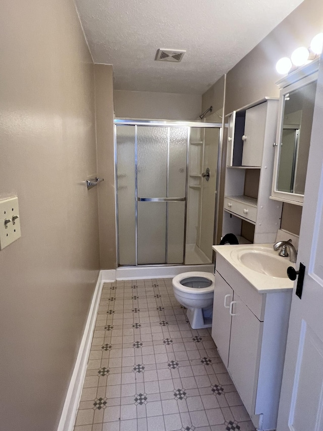 bathroom with visible vents, toilet, a stall shower, a textured ceiling, and vanity