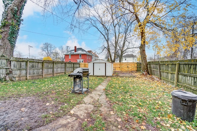 view of yard with an outbuilding, a fenced backyard, and a storage unit