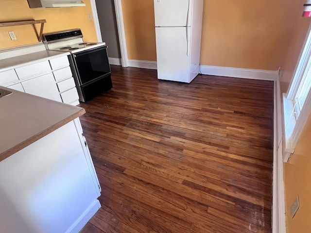 kitchen featuring dark wood-style flooring, range with electric stovetop, white cabinetry, freestanding refrigerator, and wall chimney exhaust hood