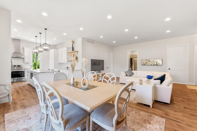 dining space featuring recessed lighting, visible vents, light wood-style flooring, and an inviting chandelier