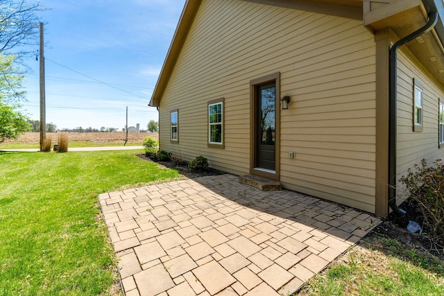 rear view of house with a lawn and a patio