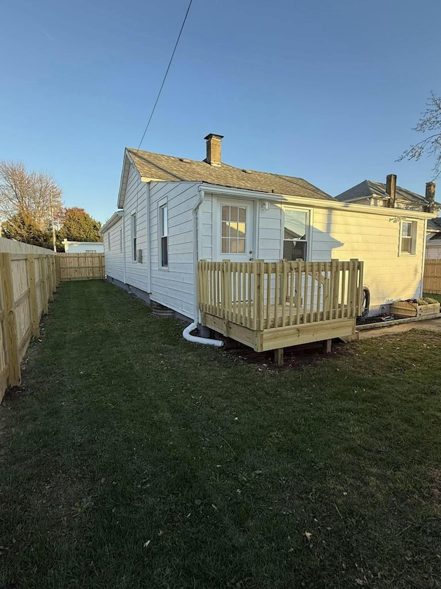 rear view of property with a deck and a lawn