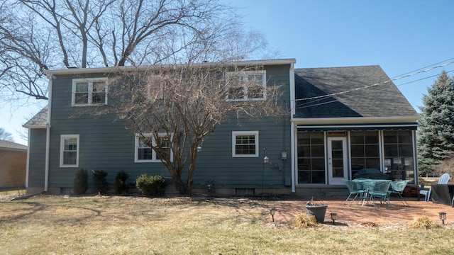 rear view of house featuring a lawn and a shingled roof