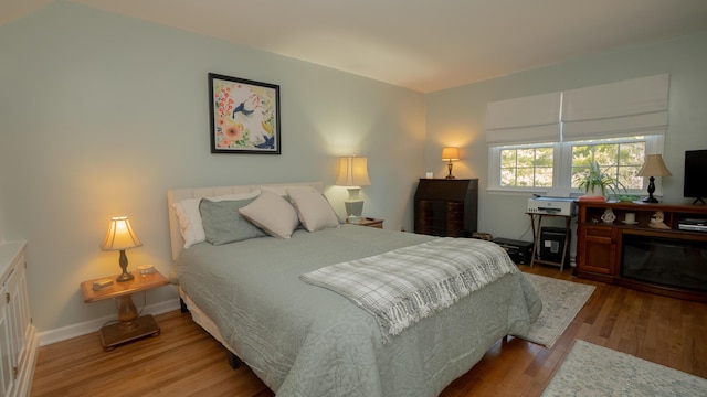 bedroom featuring baseboards and wood finished floors