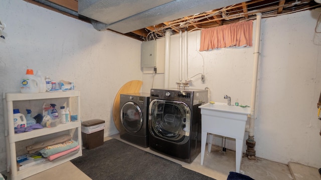 clothes washing area featuring a sink, laundry area, electric panel, and washer and clothes dryer