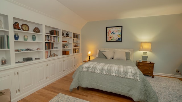 bedroom featuring light wood-style flooring and vaulted ceiling