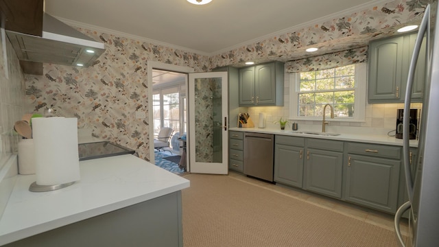 kitchen with wallpapered walls, a sink, extractor fan, appliances with stainless steel finishes, and crown molding