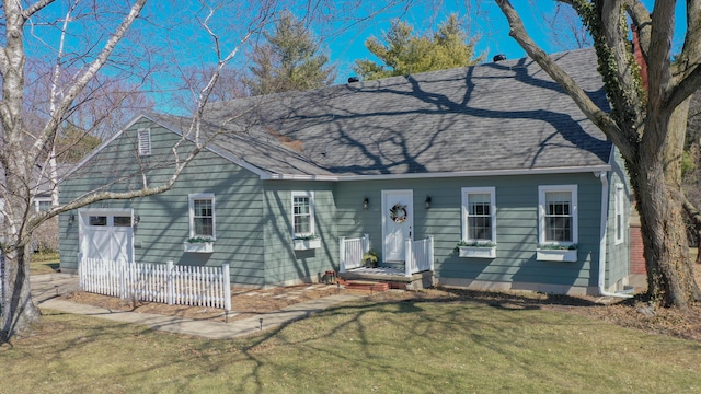 view of front of property featuring roof with shingles and a front yard