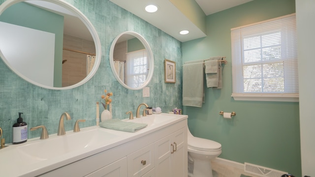 full bathroom featuring a sink, toilet, and a wealth of natural light